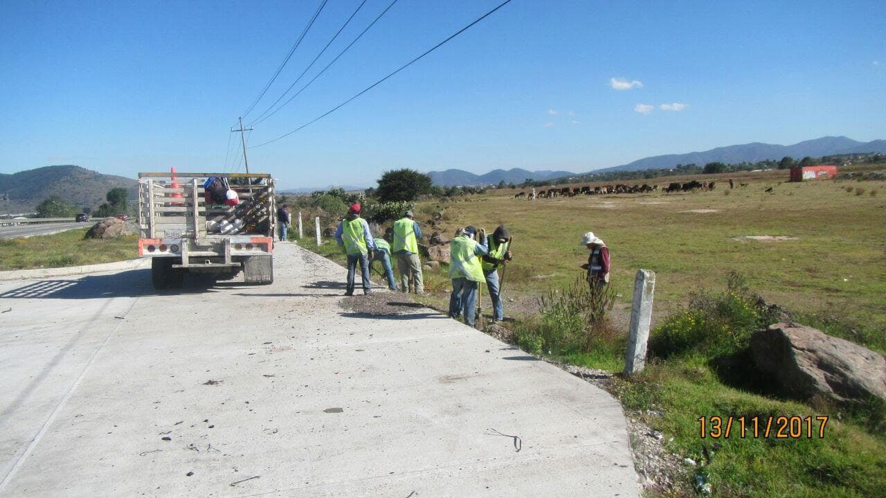 Cuadrilla instalando cercado de derecho de vía SICT junto a carretera
