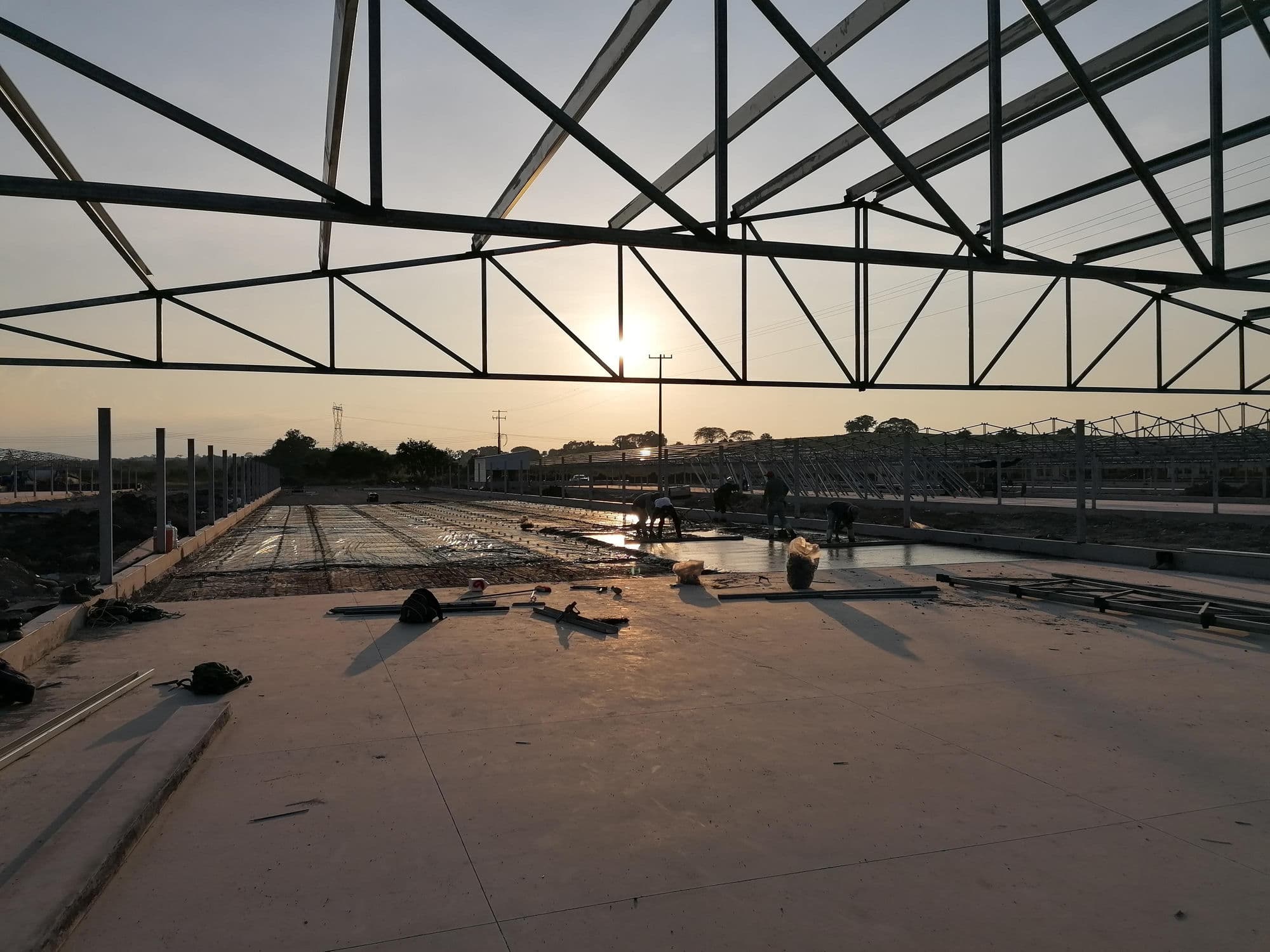 Estructura de acero para nave industrial en construcción, al atardecer